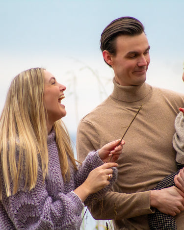 Glad familie får taget professionelle billeder af en fotograf, som julegave til sønnens bedsteforældre  